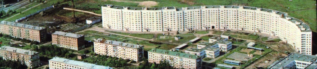 С высоты птичьего полета видно большое здание с зеленой крышей и зеленой крышей. Здание кажется...